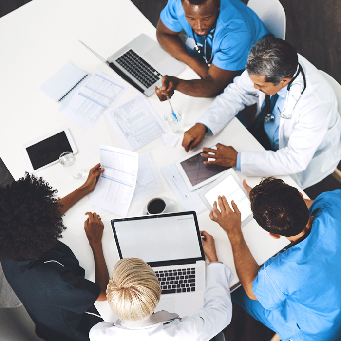 Medical team reviewing budget and reports in hospital office.