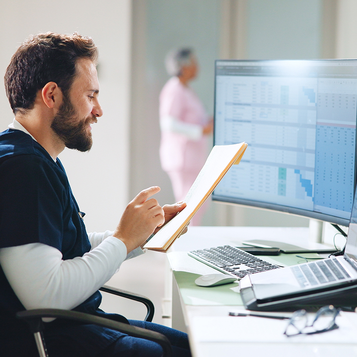 Nurse reviewing financial reports and planning quarterly schedule